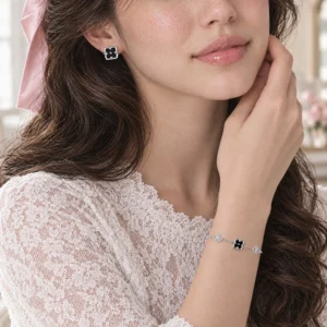 Her in white lace wearing the Midnight Bloom Set, black onyx flower earrings and the matching sterling silver bracelet